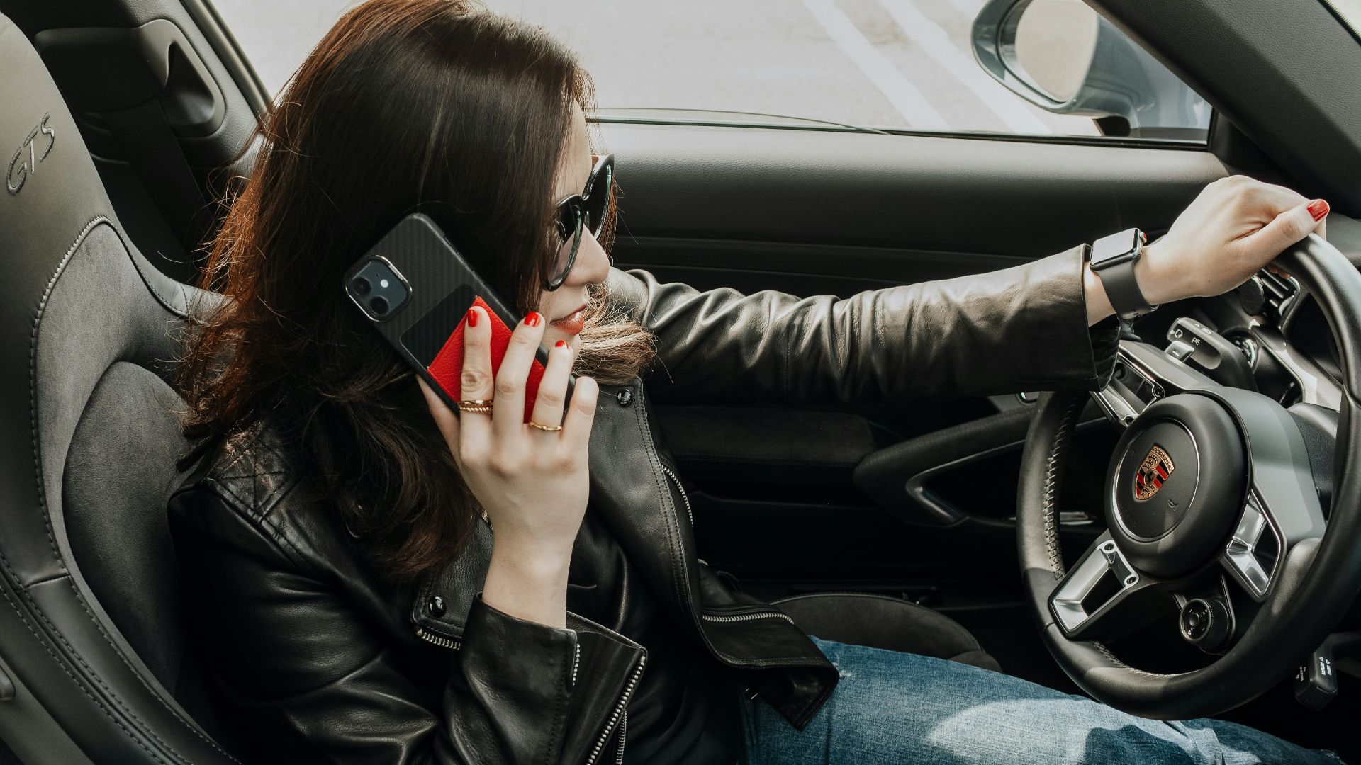 a woman sitting in a car talking on a cell phone