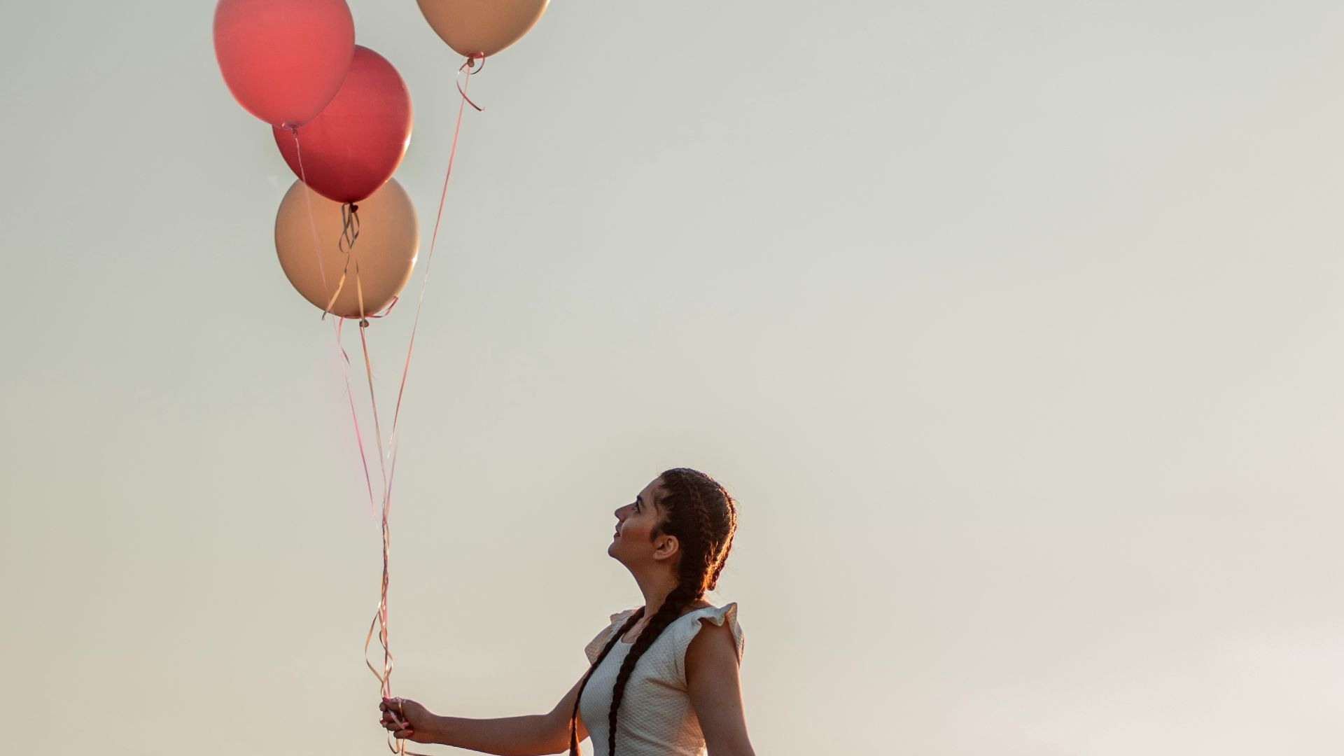 woman in blue and white dress holding balloons