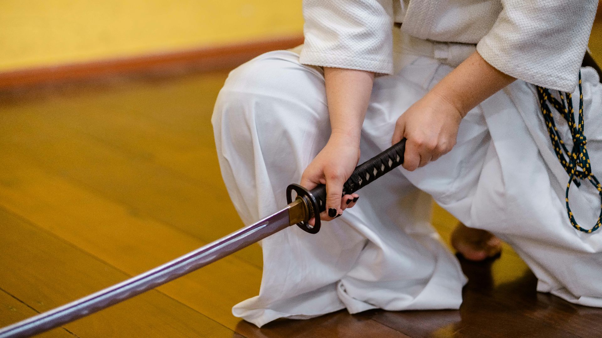 man holding black and gray katana