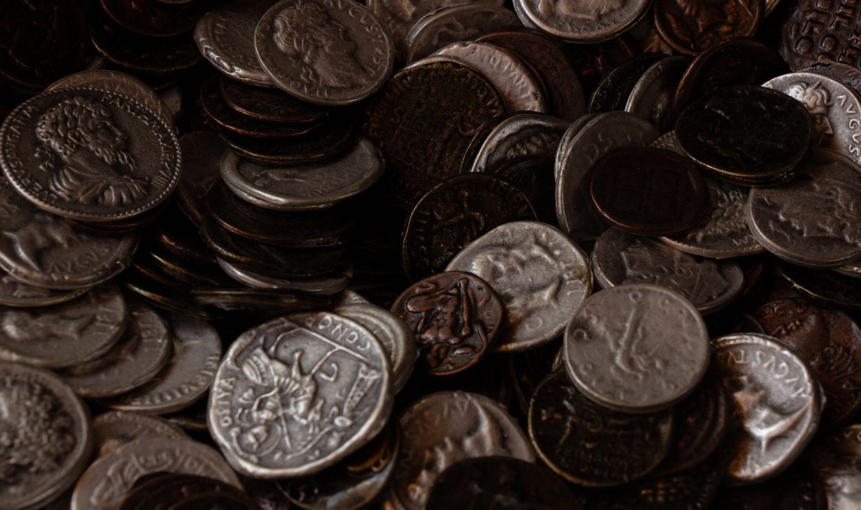 A pile of ancient coins from different eras, highlighting the craftsmanship and historical significance of old currency