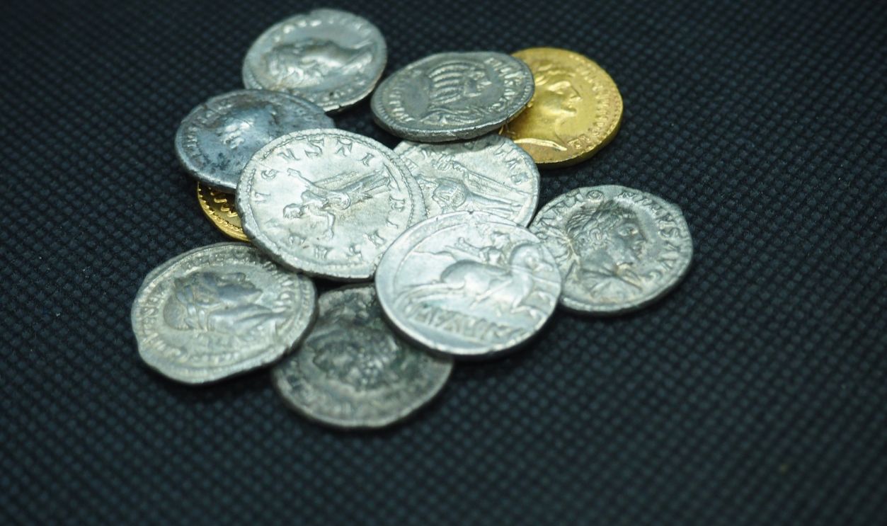 Roman gold and silver coins on a black background