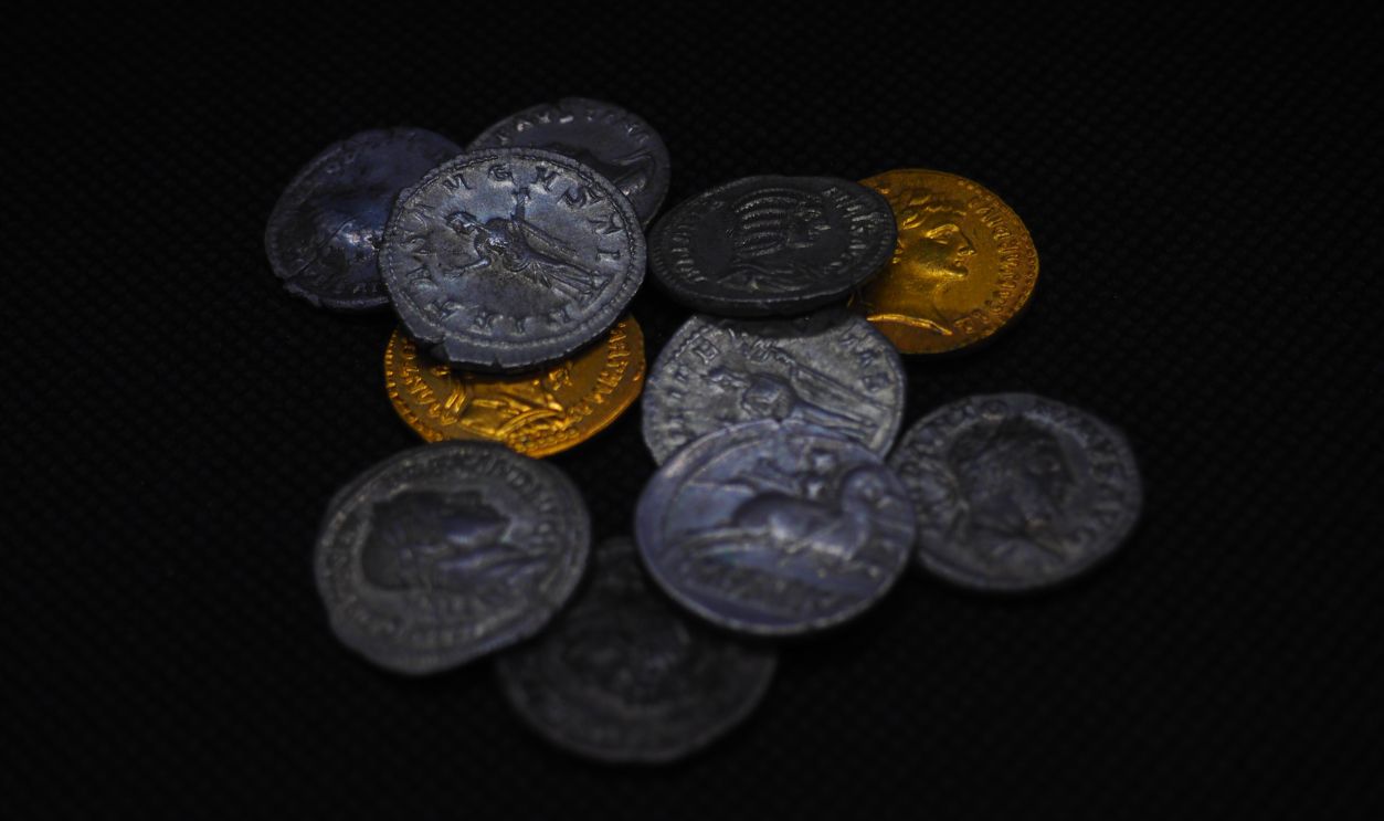 Roman gold and silver coins on a black background