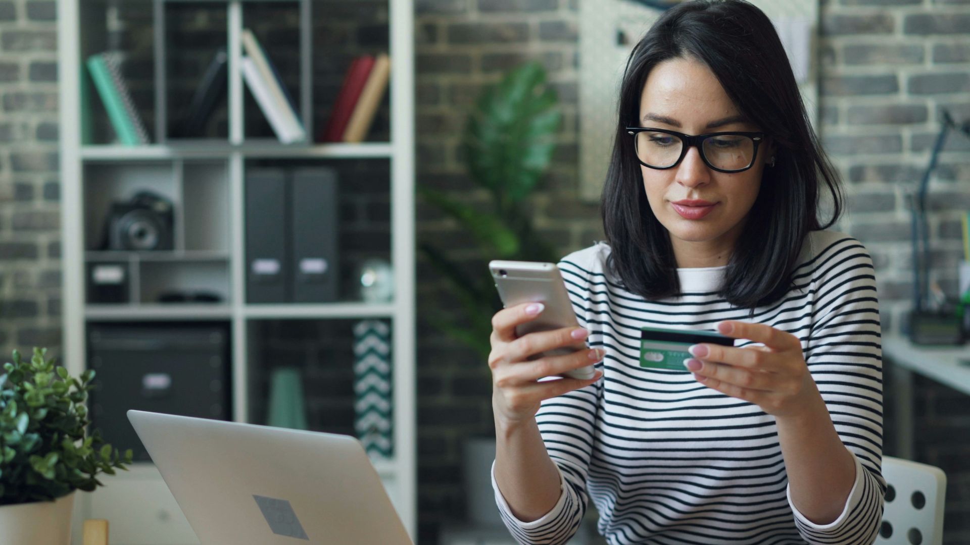a woman sitting at a table looking at her cell phone