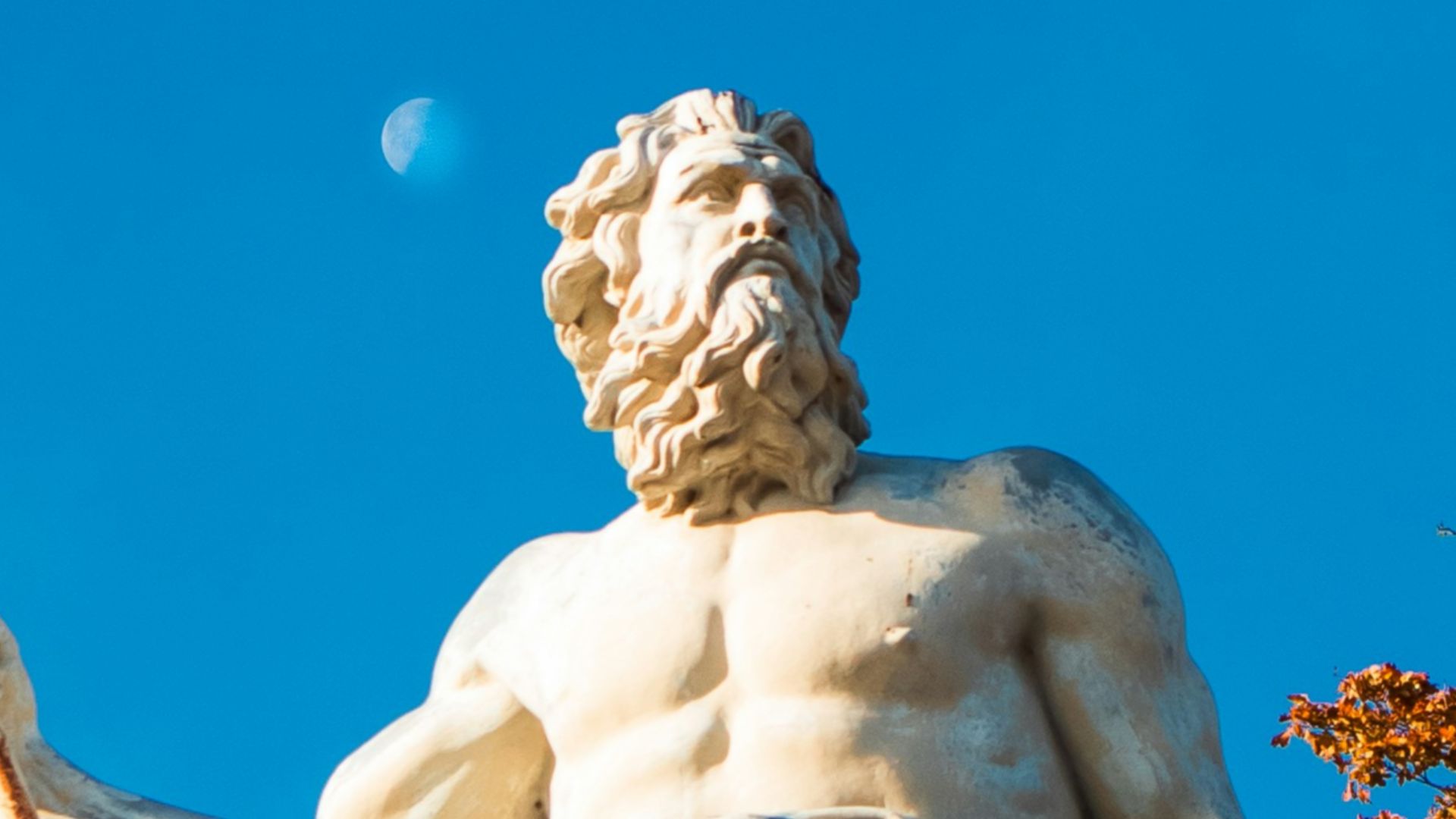 A statue of a man holding a spear on top of a building