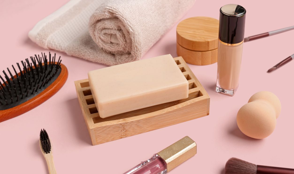 Set of cosmetic products and bath supplies on pink background