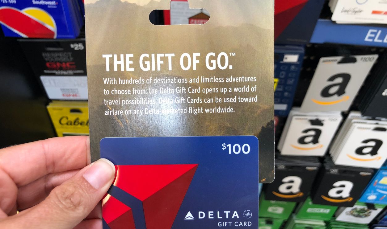 New Hope, MN - July 23, 2019: Caucasian hand holds up a Delta Airlines gift card while shopping in a supermarket, for use on travel