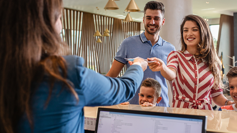Smiling family of four in the hotel lobby check in