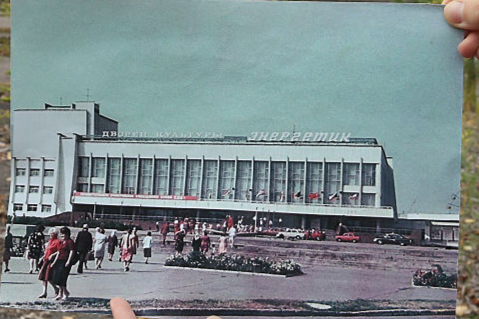 : An assistant holds up a photo showing the city of Pripyat's main square and the 