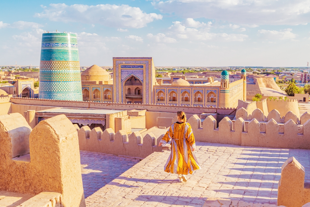 Woman in a traditional robe admires the town of Ichan-Kala