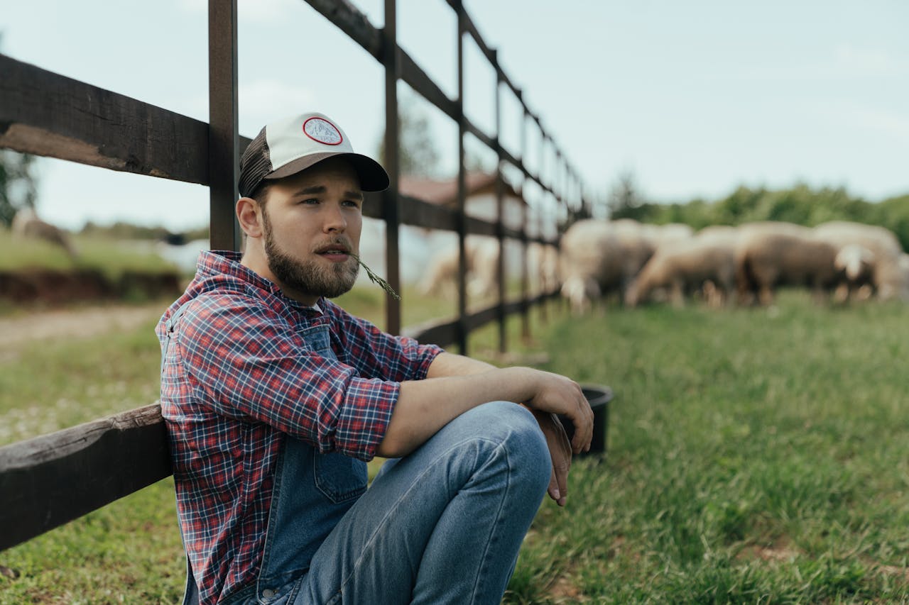 Man in Blue Denim Jeans Sitting on Grass.
