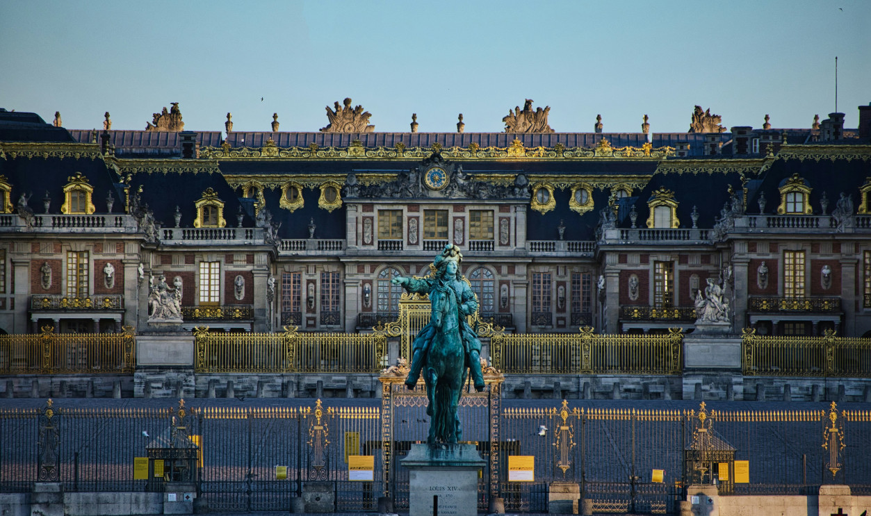 green statue of man riding horse near white building during daytime