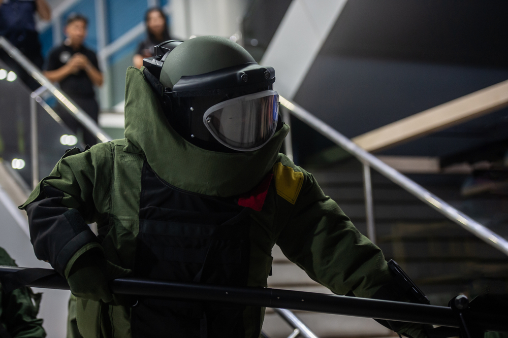 The police in The explosive ordnance disposal suit (BOMB Suit) working in the indoor of airport terminal
