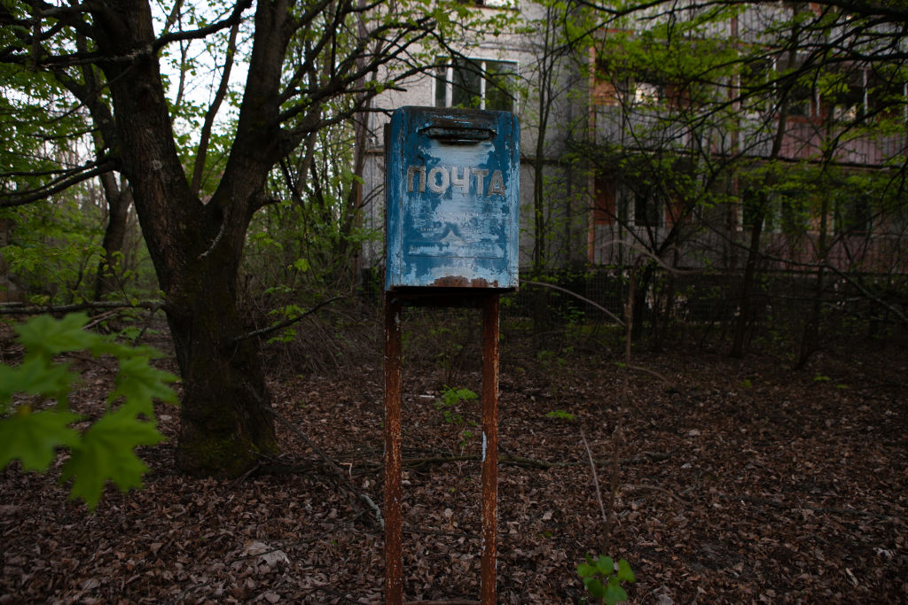 A rusty post box remains in front of an abandoned residential building on April 25, 2016 in Prypiat, Ukraine.