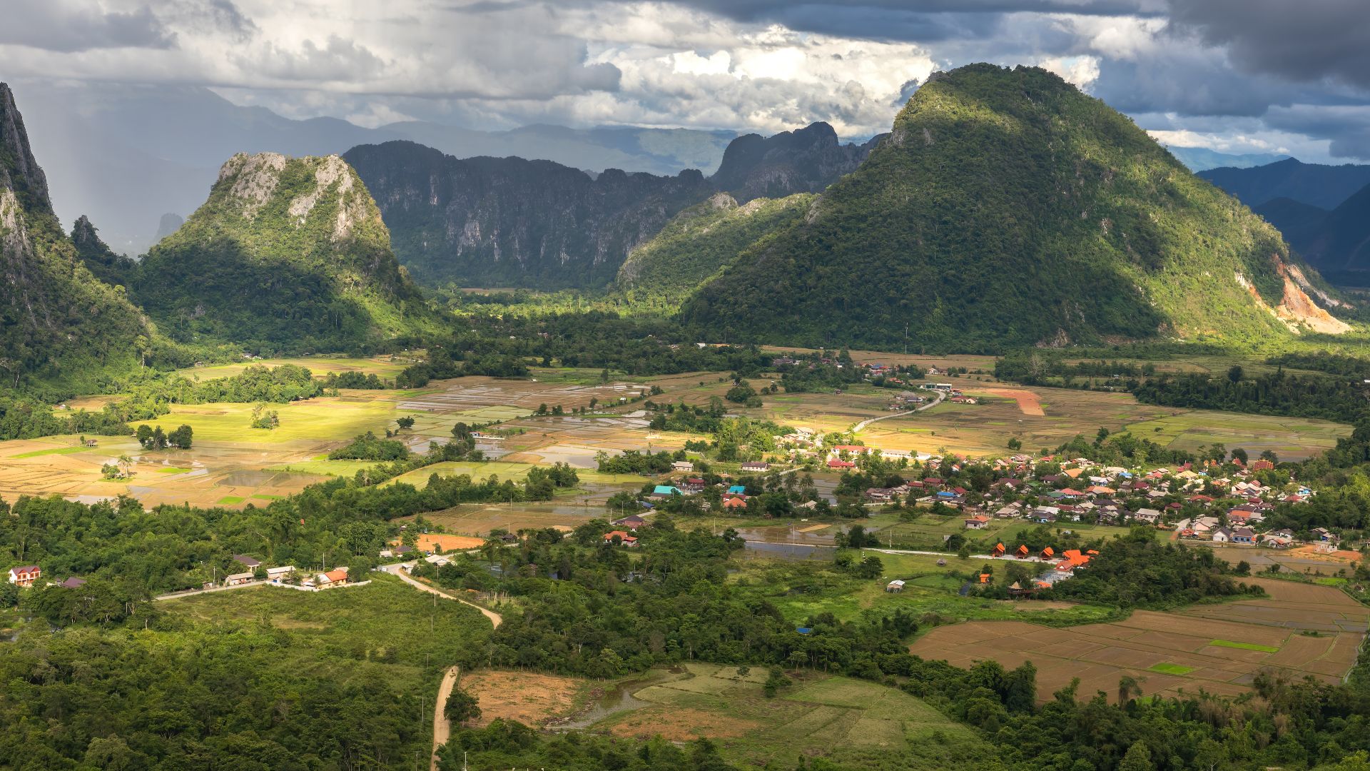 File:Karst peaks and green paddy fields under a stormy sky, South view from Mount Nam Xay, Vang Vieng, Laos.jpg