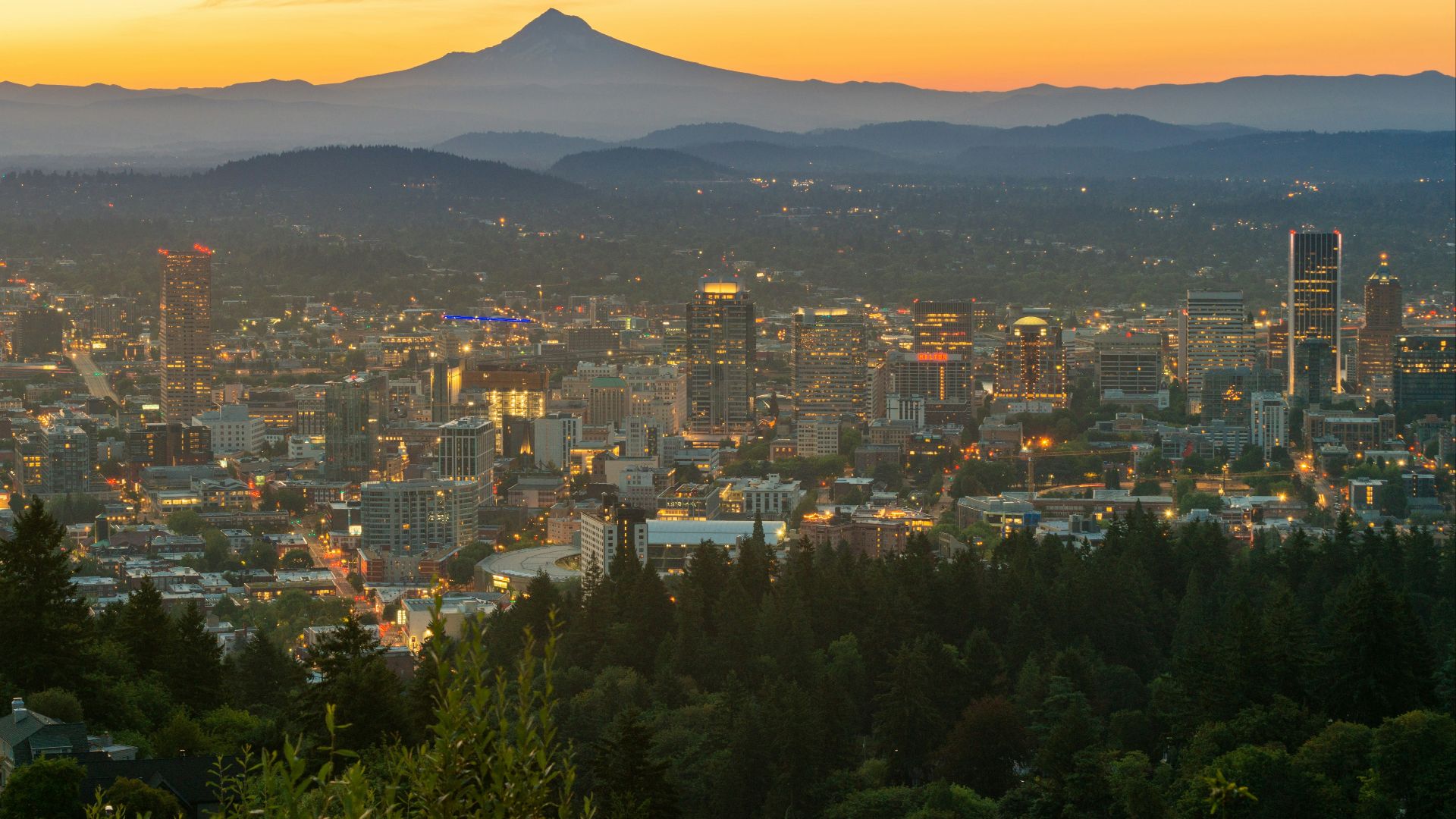 city with high rise buildings near mountain during sunset