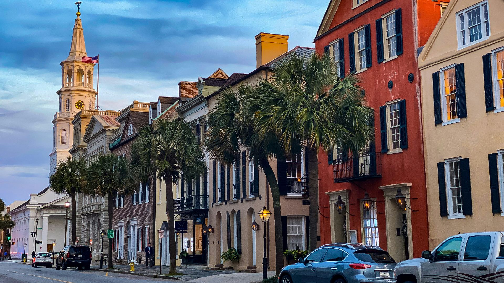 cars parked beside brown concrete building during daytime
