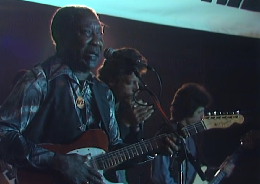 Muddy Waters playing guitar on stage
