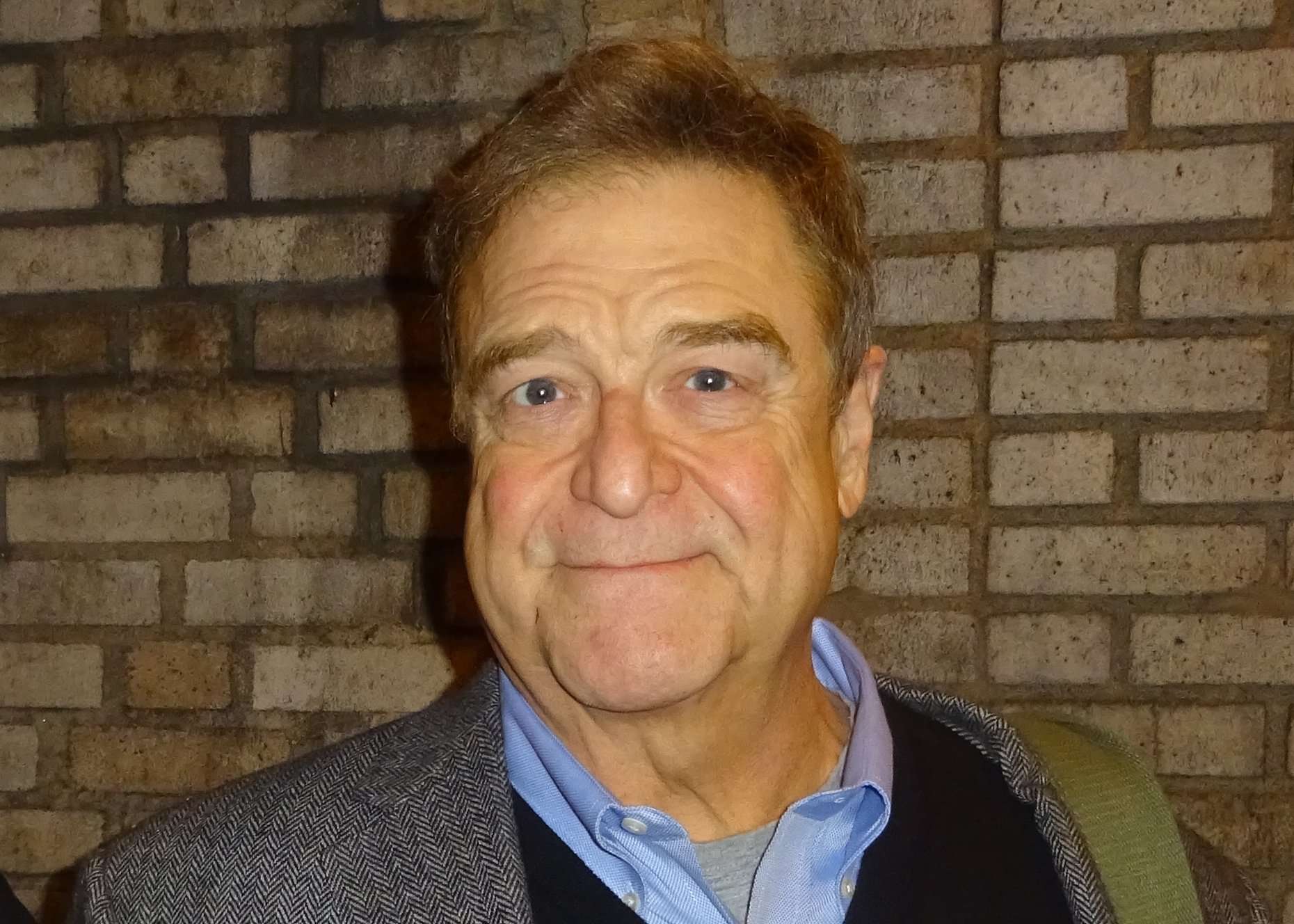John Goodman wearing a grey blazer