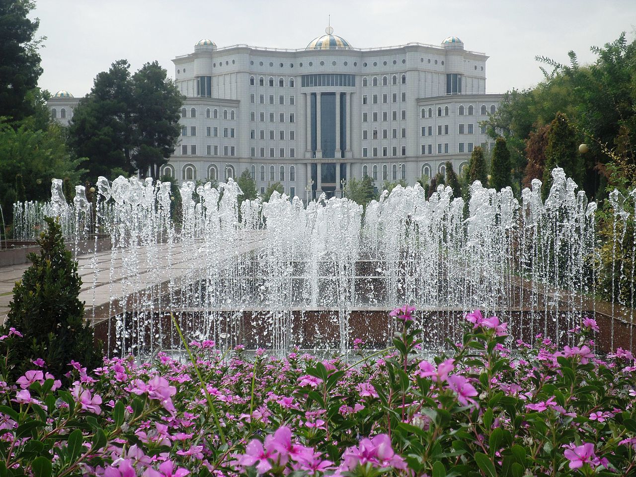 Fountain and flowerbed flowers on a background of the building of the National Library of Tajikistan in Dushanbe - 2015