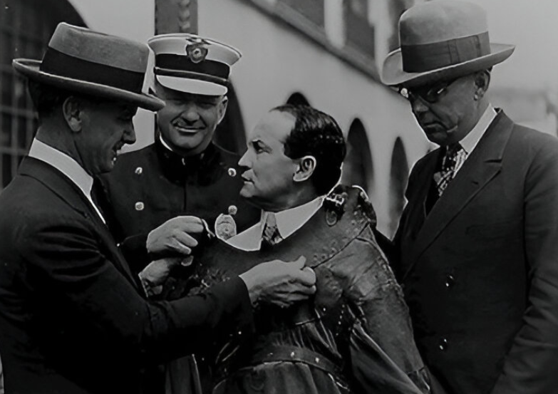 Harry Houdini is shown secured in a straitjacket