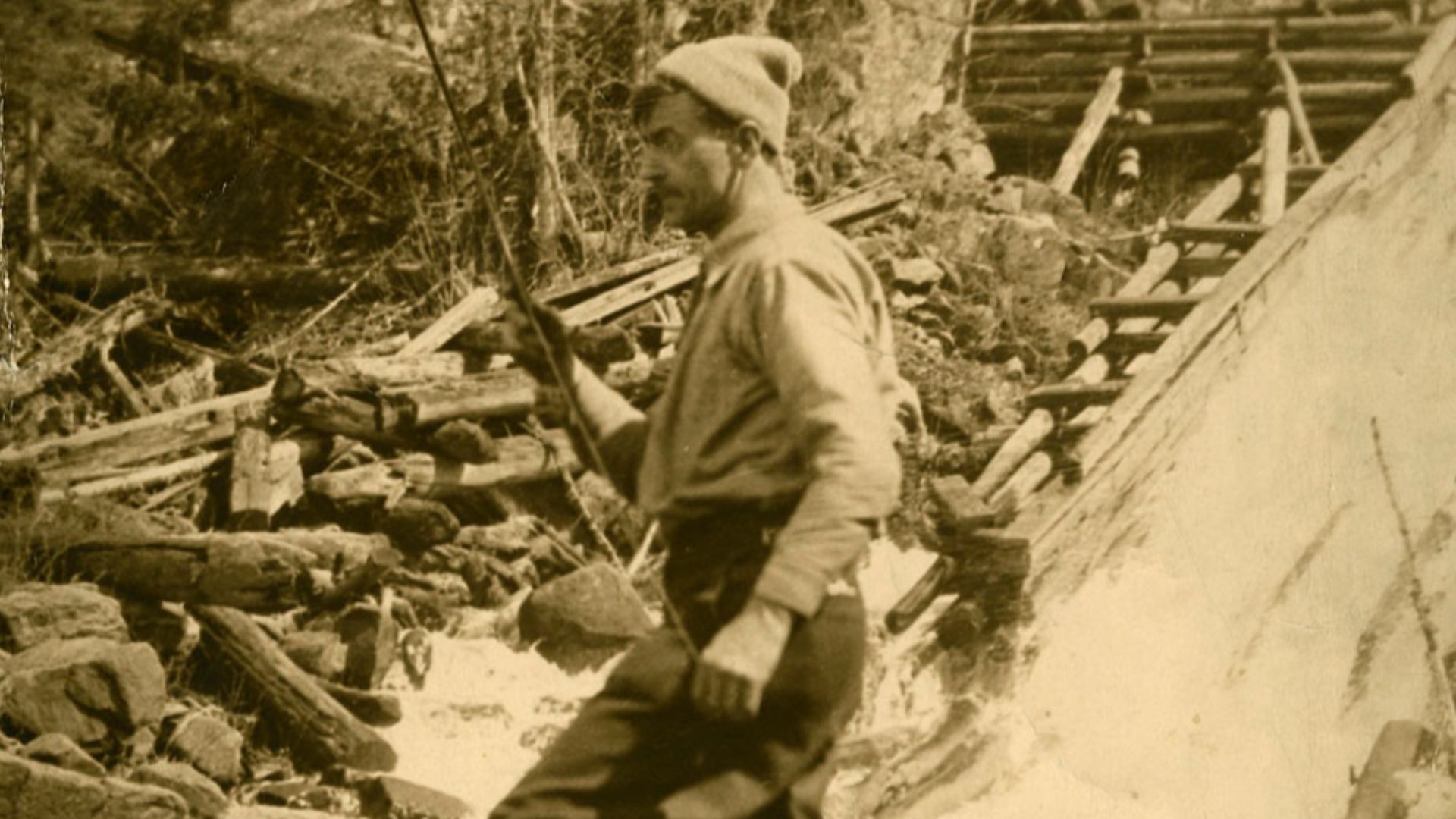 File:Tom Thomson, standing on a rock fishing in moving water.jpg