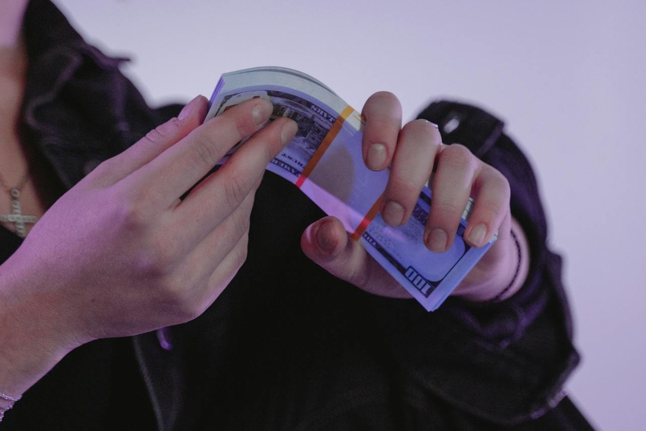 Person Holding a Bundle of Money