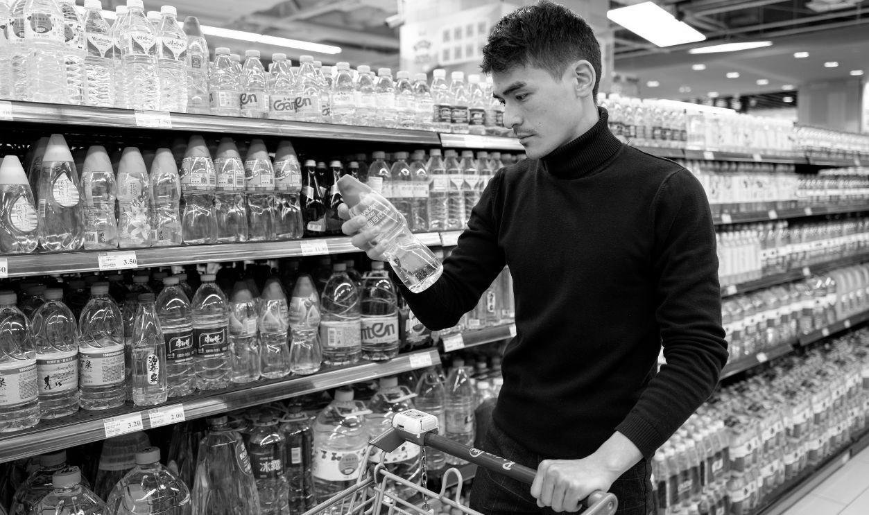 A male customer in a grocery store selects goods