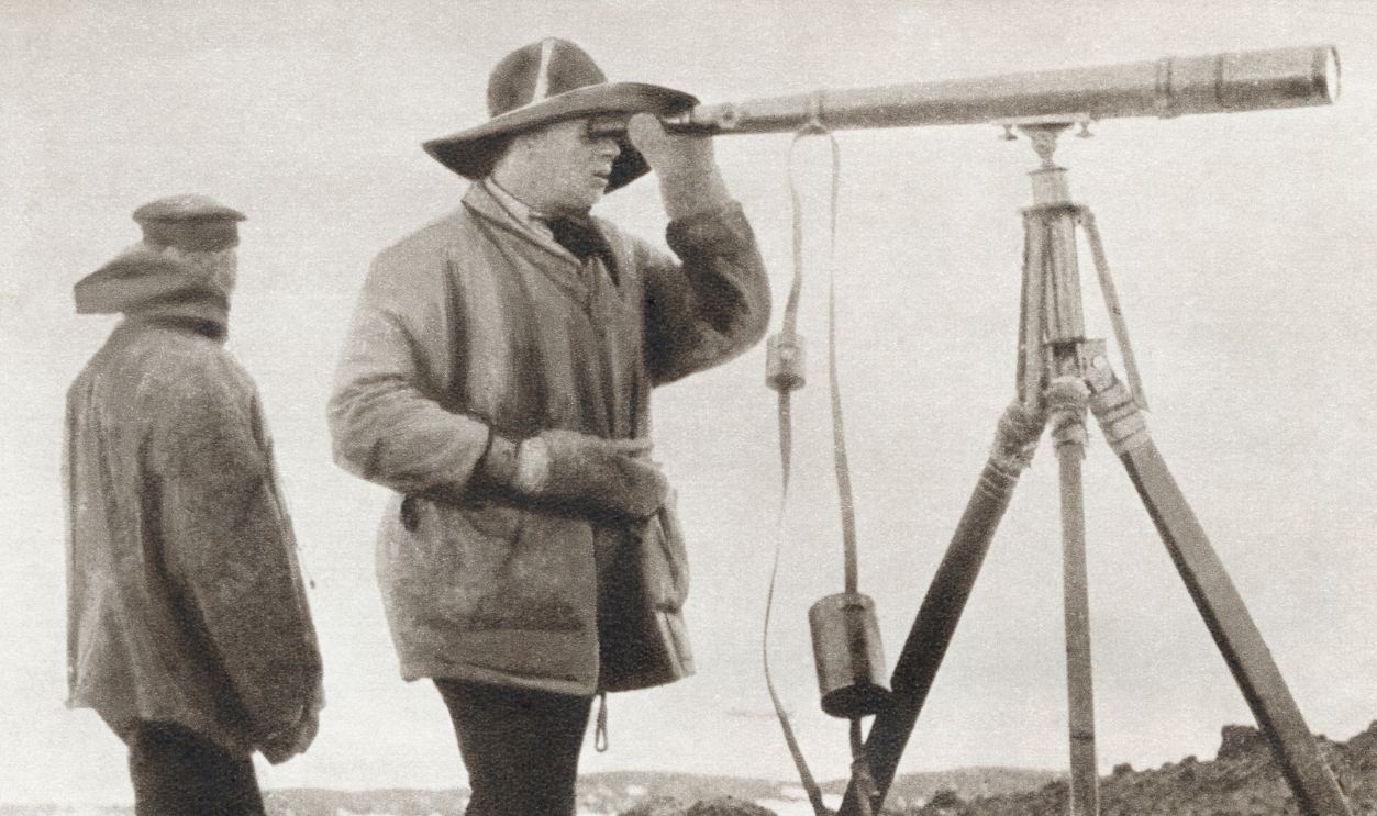 Scott looking through a telescope during The Terra Nova Expedition to the south pole in 1912