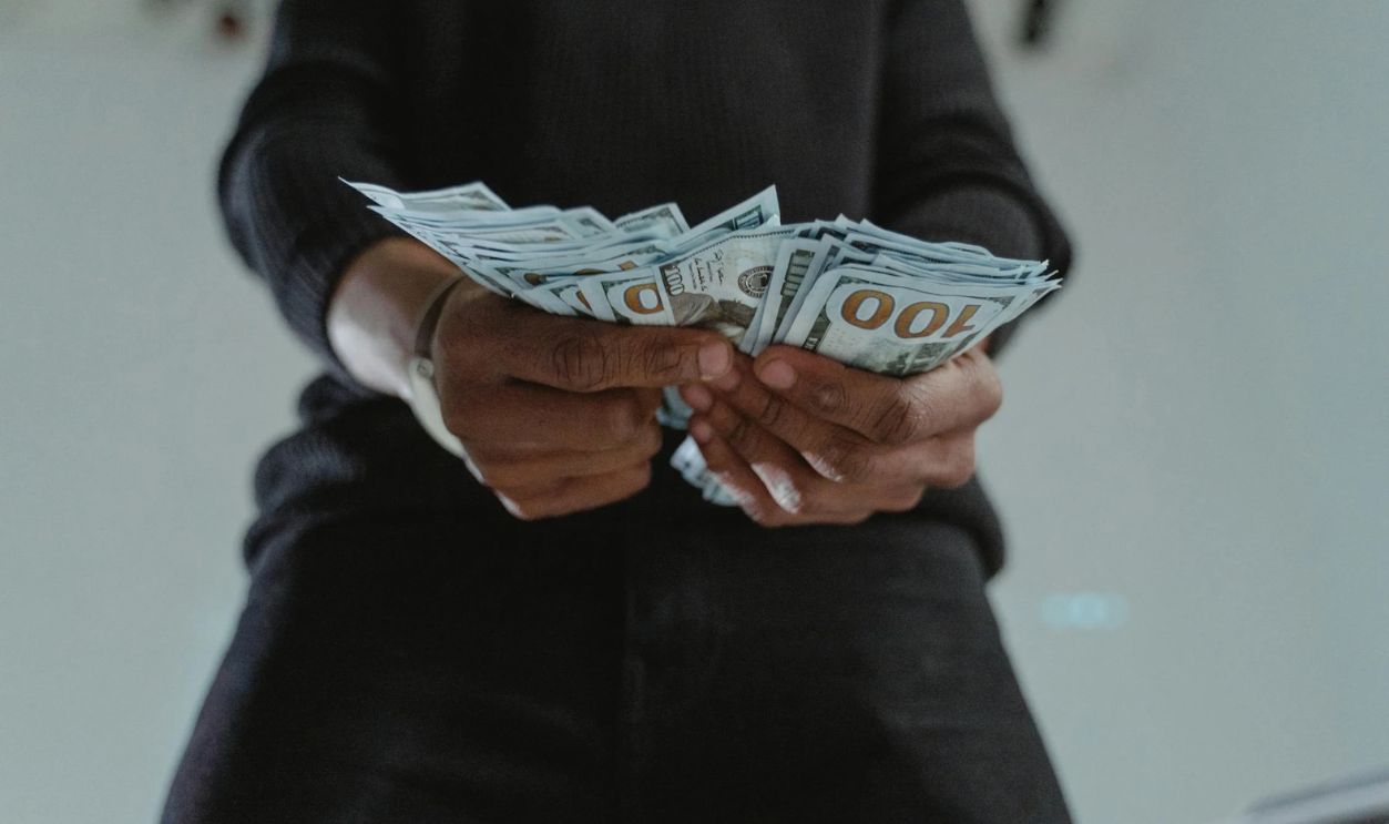 Close-Up Photo of a Person's Hands Holding Dollar Bank Notes