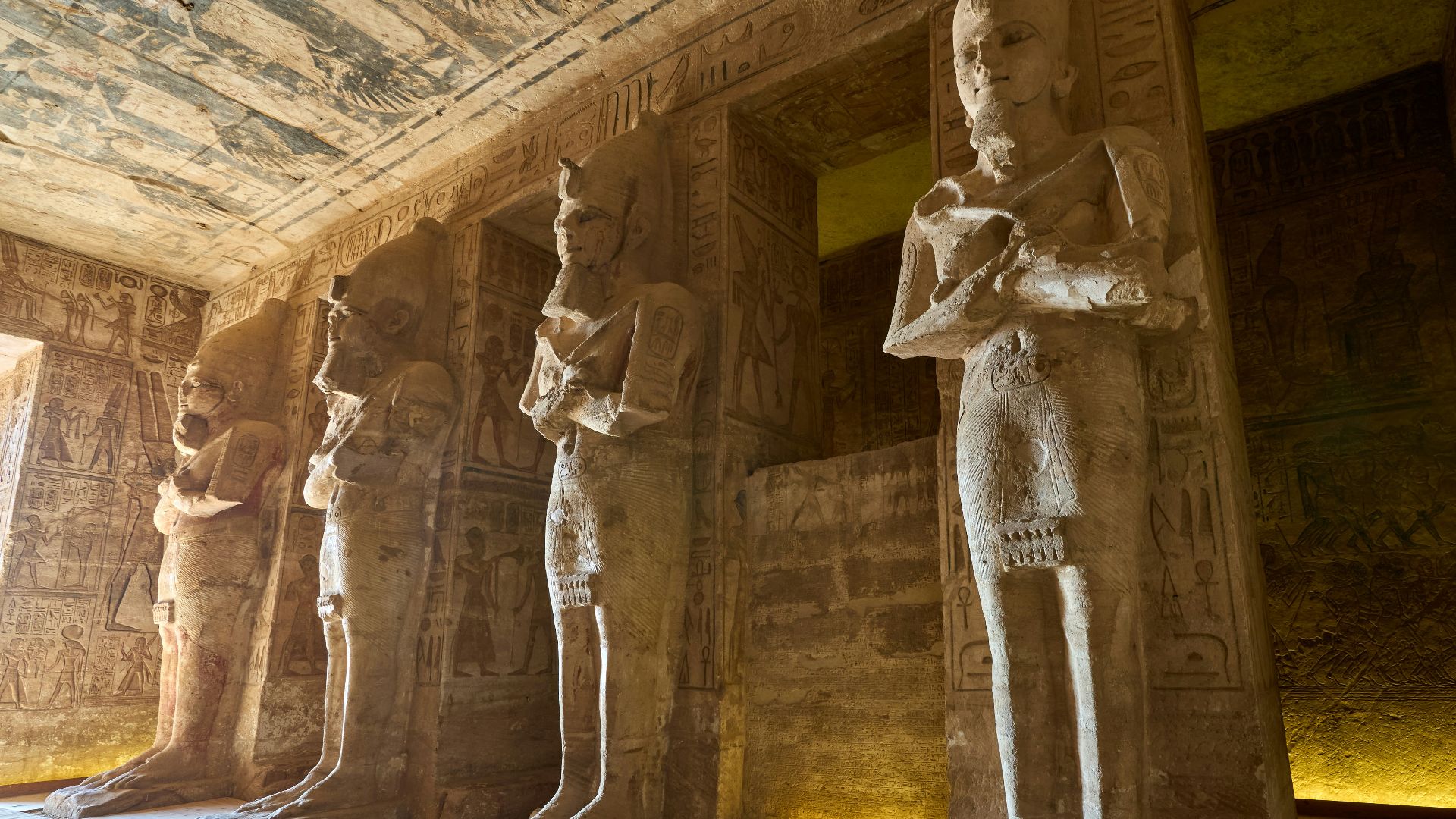 a group of statues in a room next to a wall