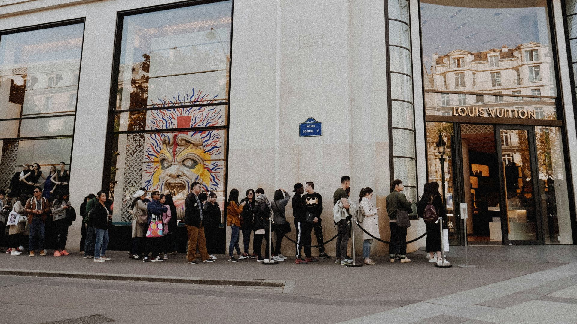 people queuing beside Louis Vuitton store