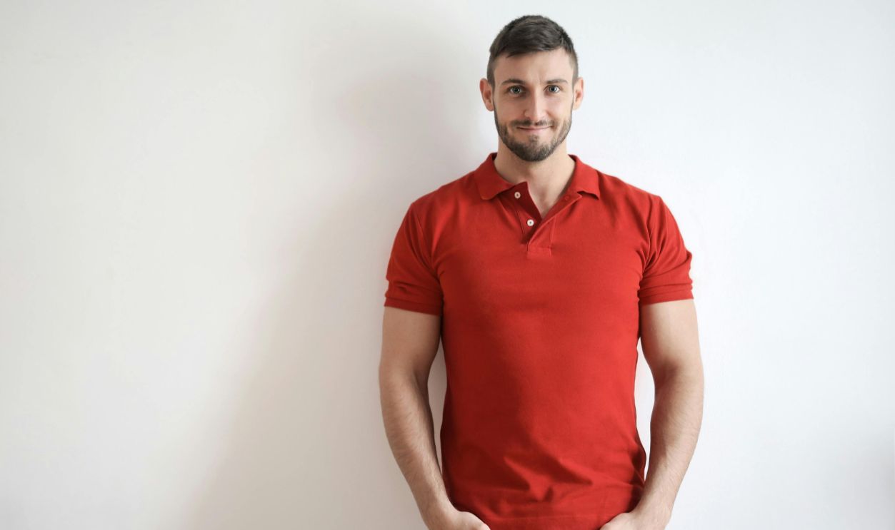 Man wearing red polo shirt and blue denim trouser
