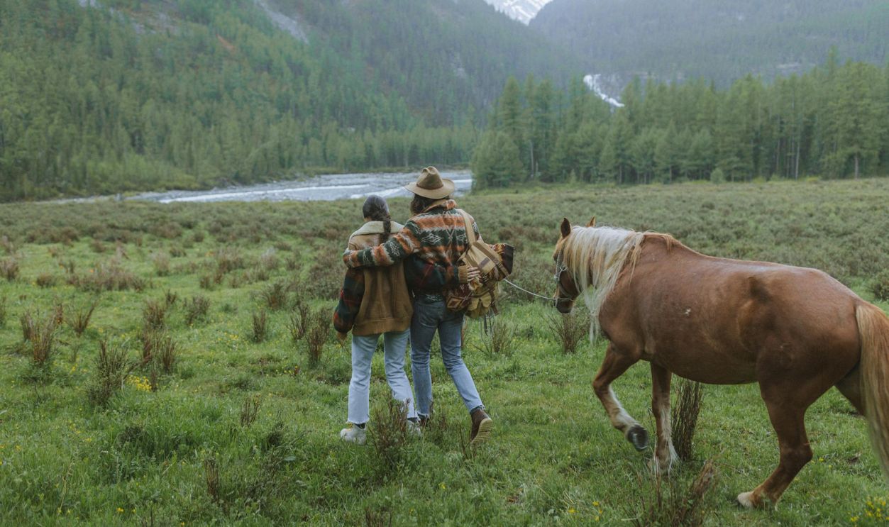 Man in Brown Jacket Standing Beside Brown Horse