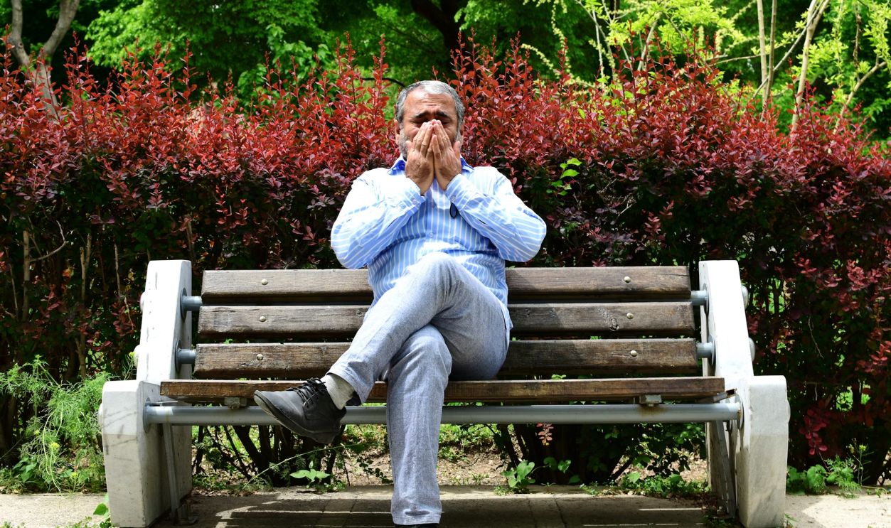 A man sitting on a bench in a park