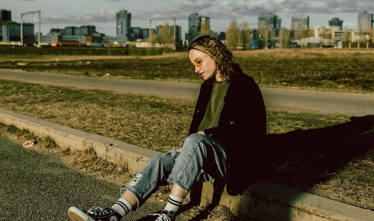 Woman sitting on sidewalk