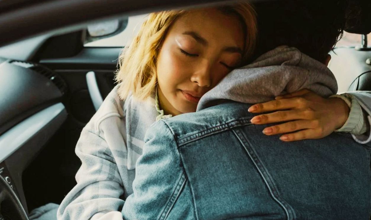 A Couple Hugging Inside a Car
