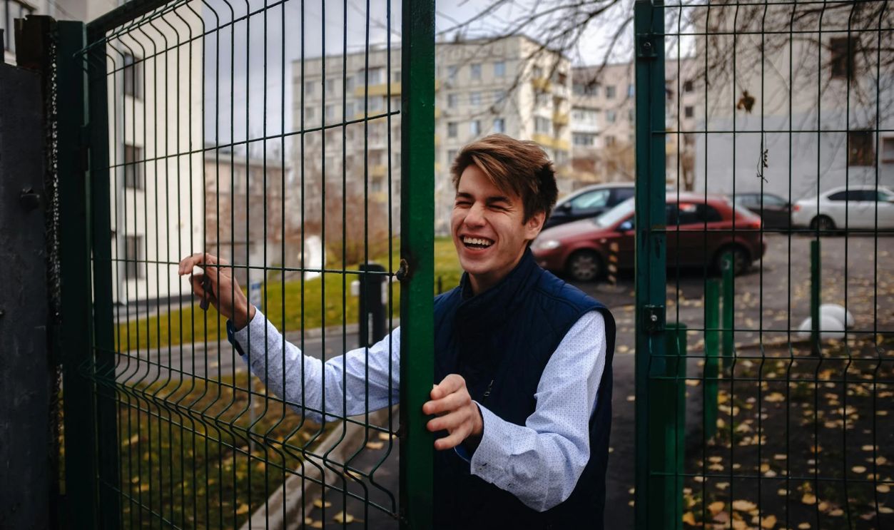 A Smiling Man Entering a Gate