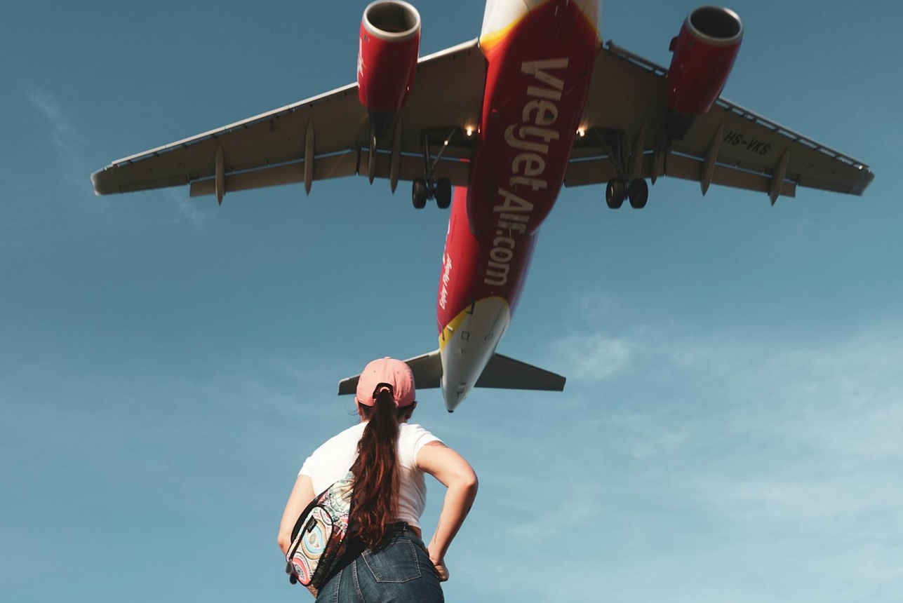 Low Angle Shot of a Woman Looking at an VietJet Airplane