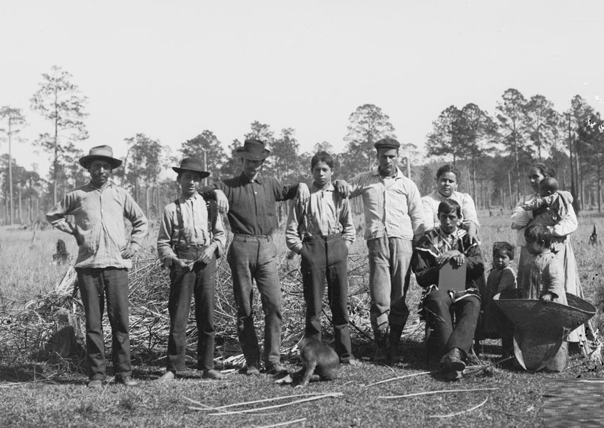 Group Of Eleven Near Meadow, One In Partial Native Dress 1909