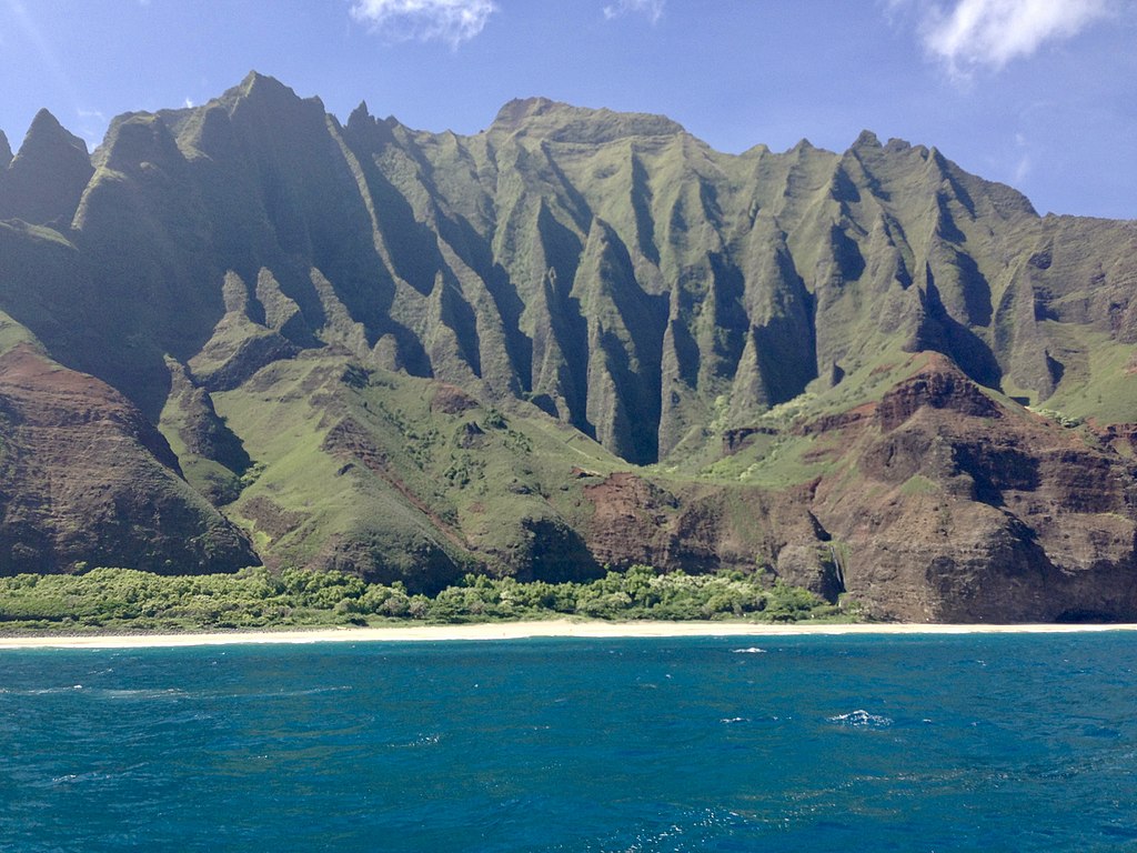 This is a picture of the Na Pali Coastline from the perspective of a person standing on a boat.