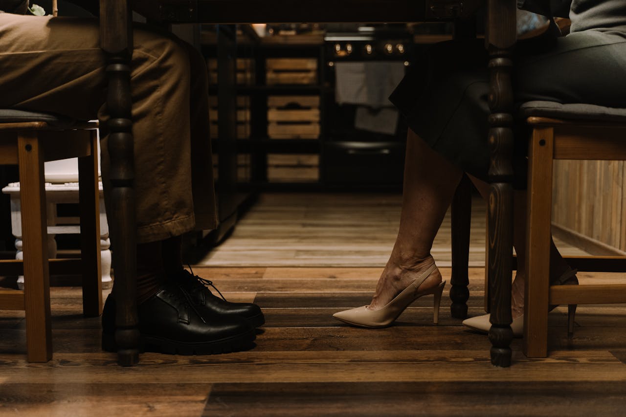 Shoes of Couple Sitting on Wooden Chairs