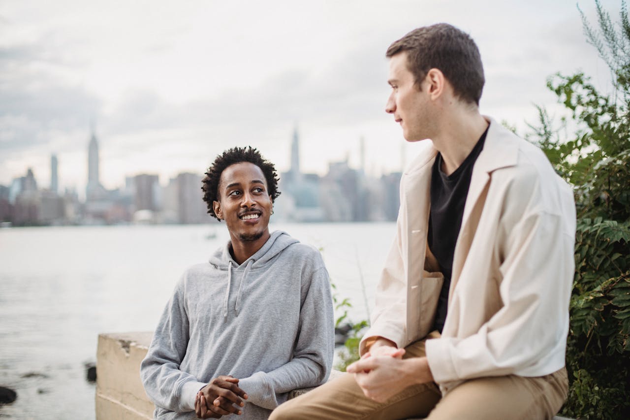 Smiling man talking to friend on river embankment