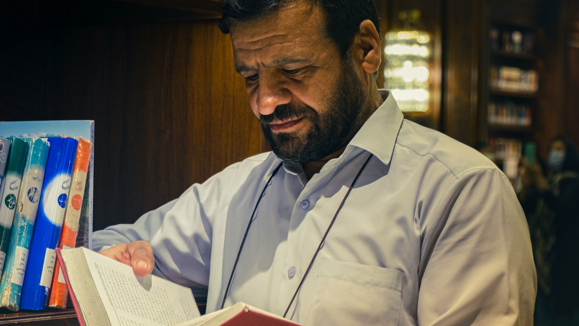 a man reading a book in a library