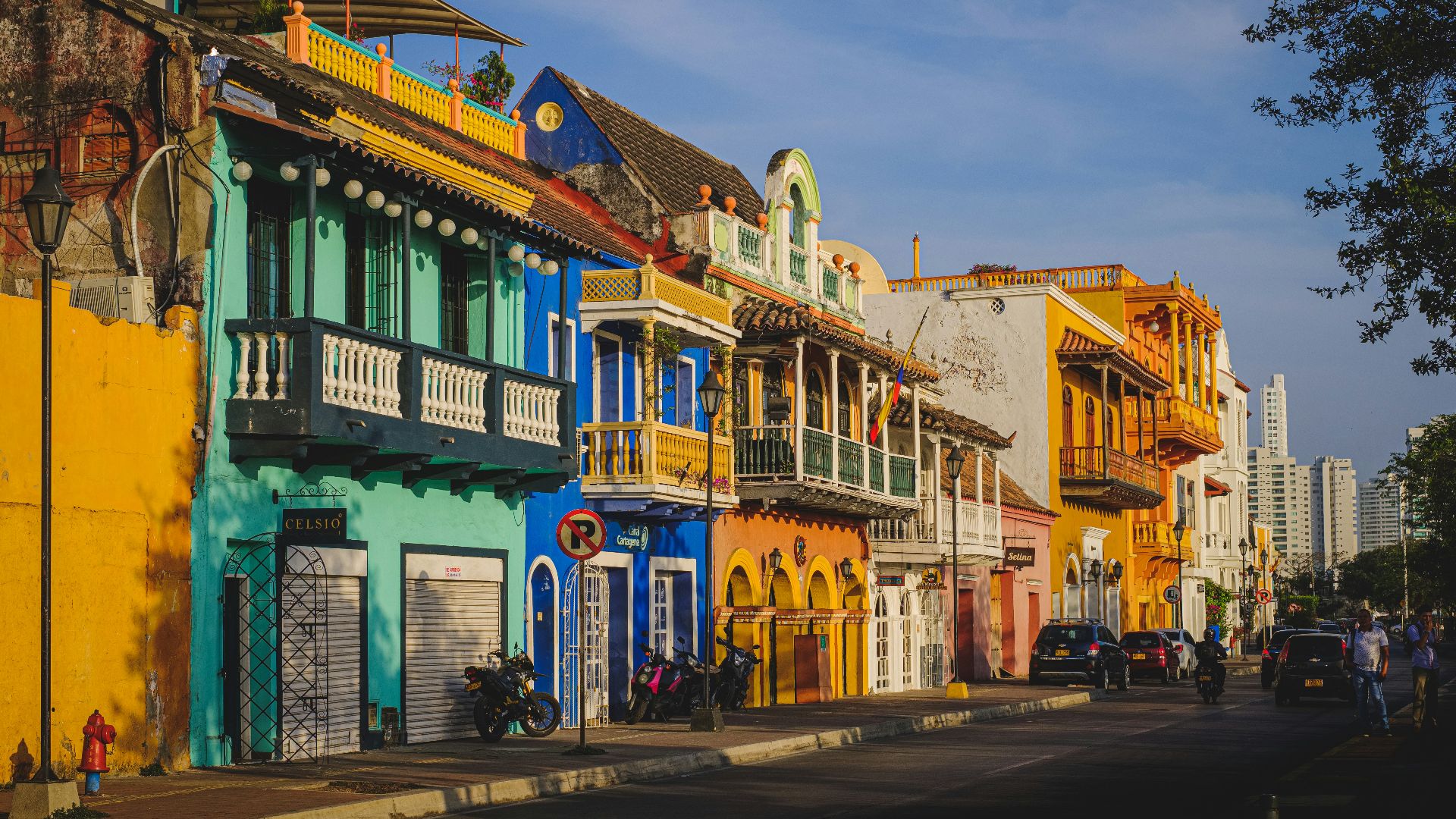 cars parked in front of green and white concrete building during daytime