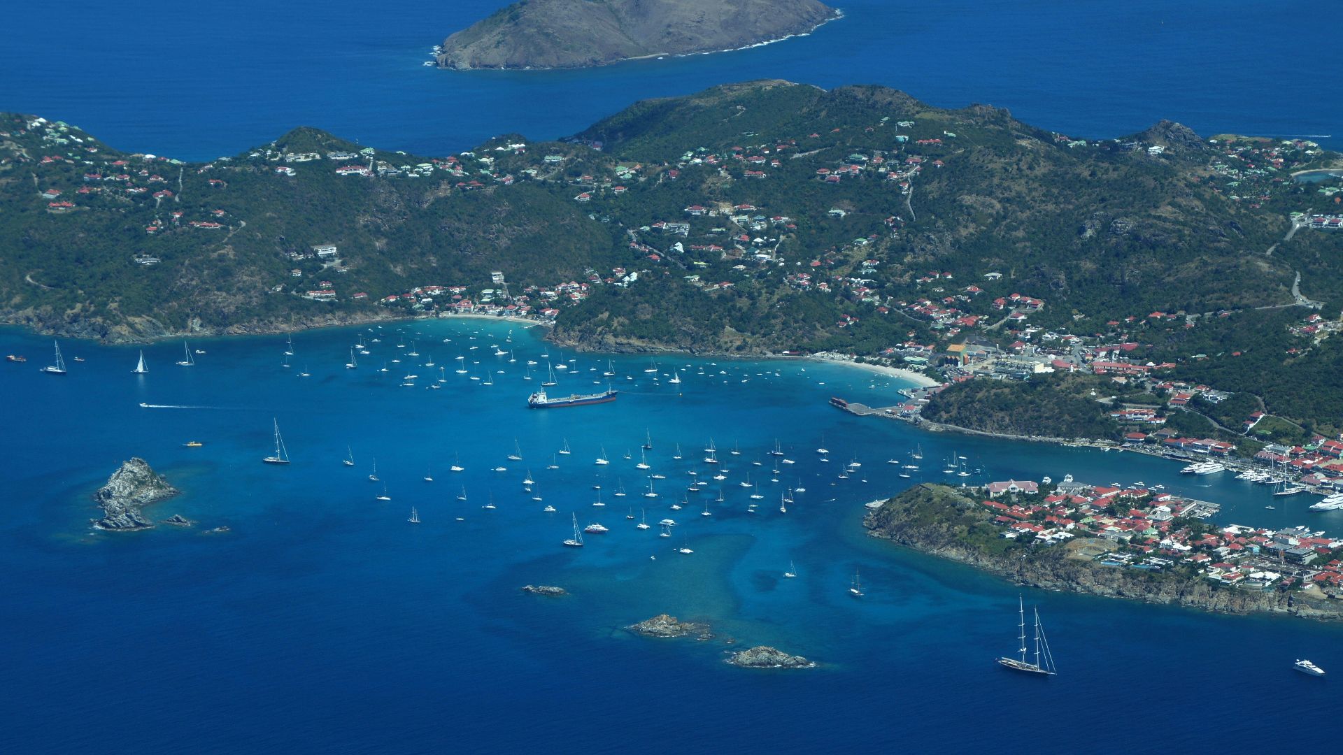 an aerial view of a small island with boats in the water