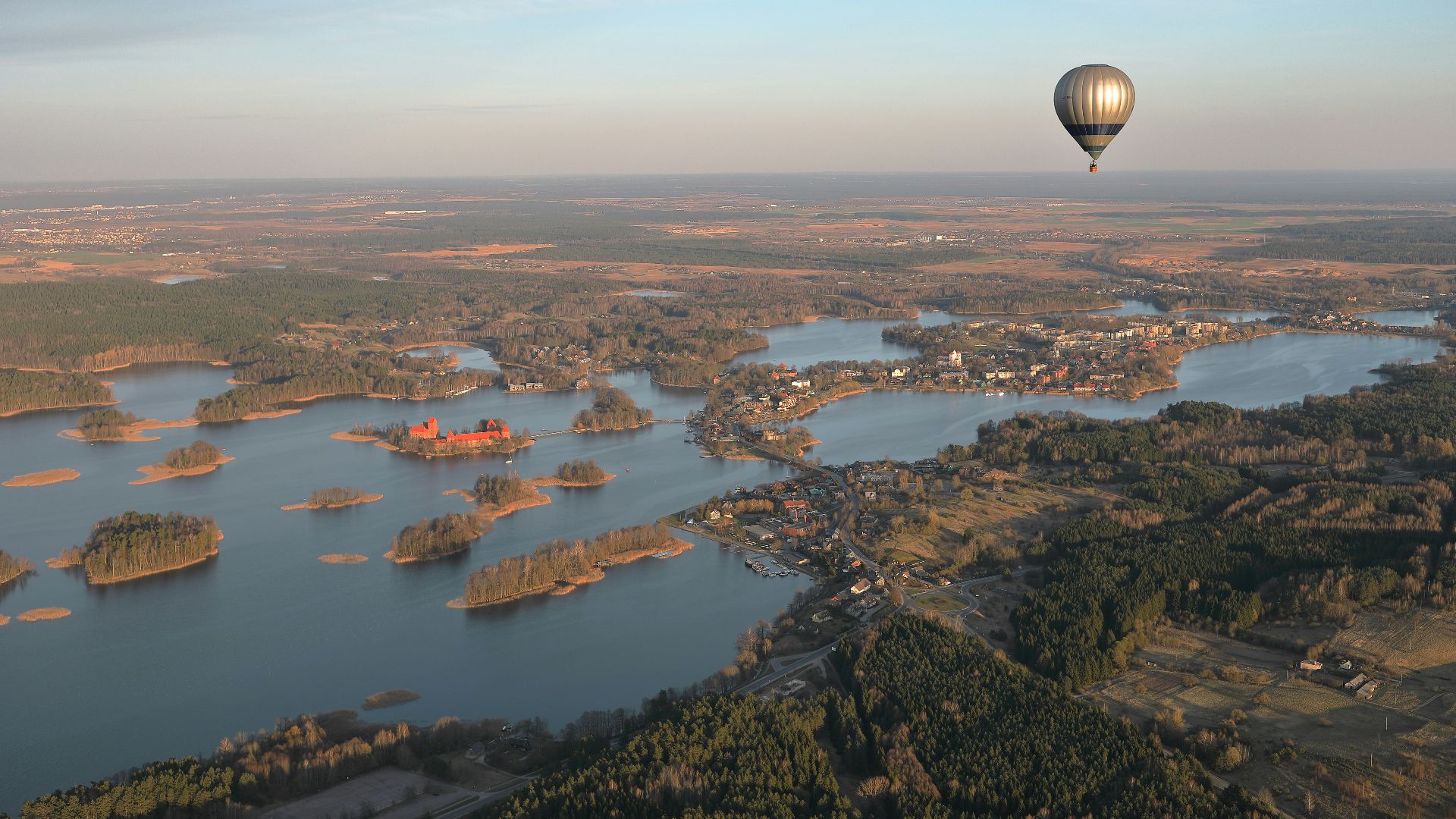 a hot air balloon flying over a large body of water