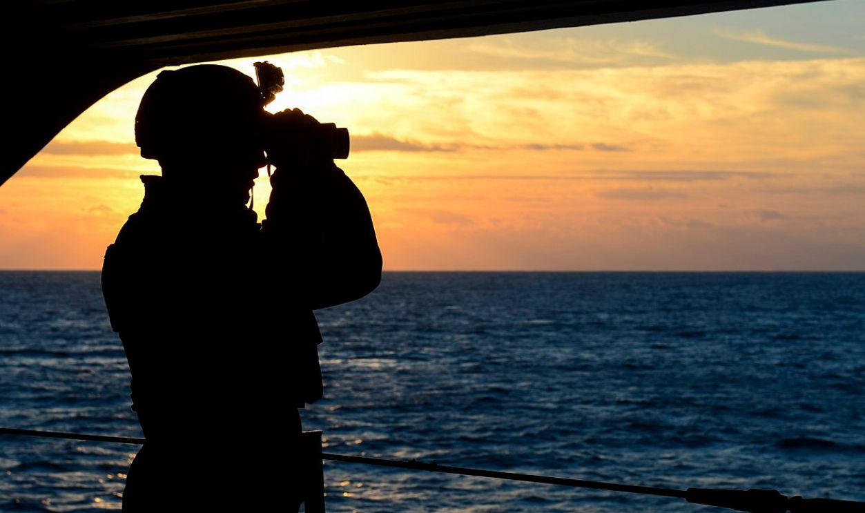 Sailor stands lookout at sea