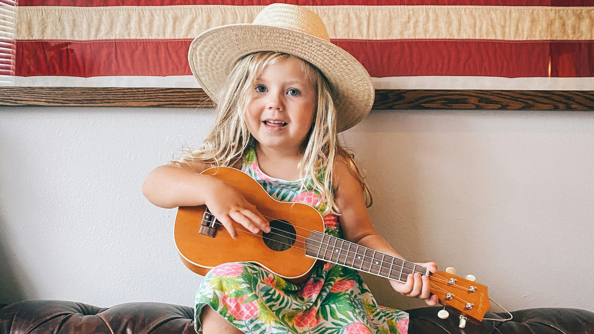 woman in brown cowboy hat and green dress sitting on black leather couch