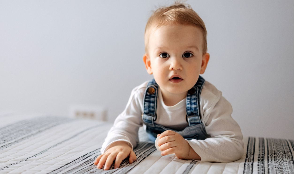 Portrait of cute little baby boy in bedroom