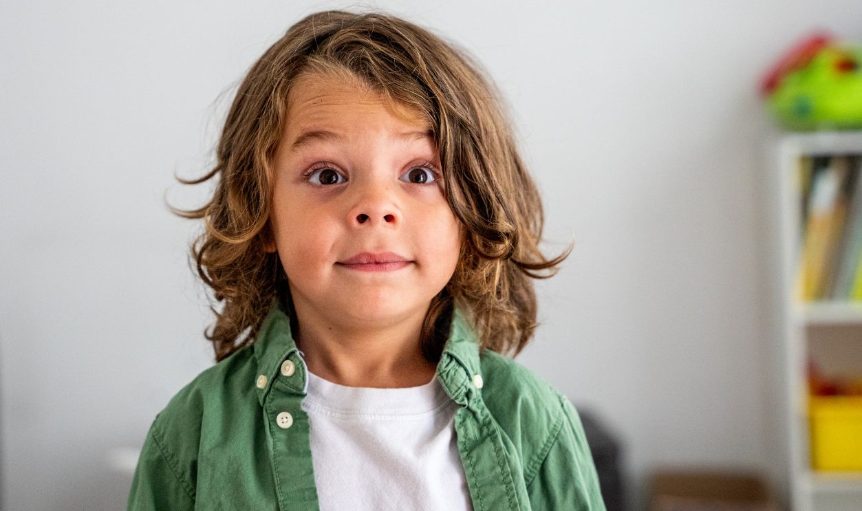 A Young Boy with Exaggerated Expressions Looking at the Camera, Portrait of a Young Boy